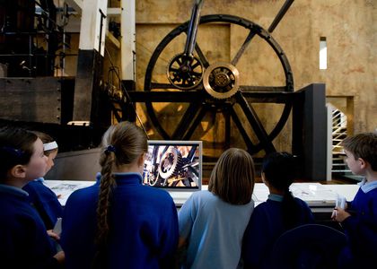 School children standing with backs to the camera, looking up at the Boulton and Watt Engine display